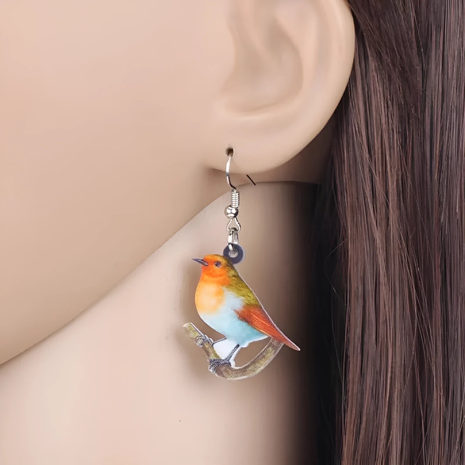 Blue Titmouse bird pendant drop earrings made from acrylic with geometric and snake design details.