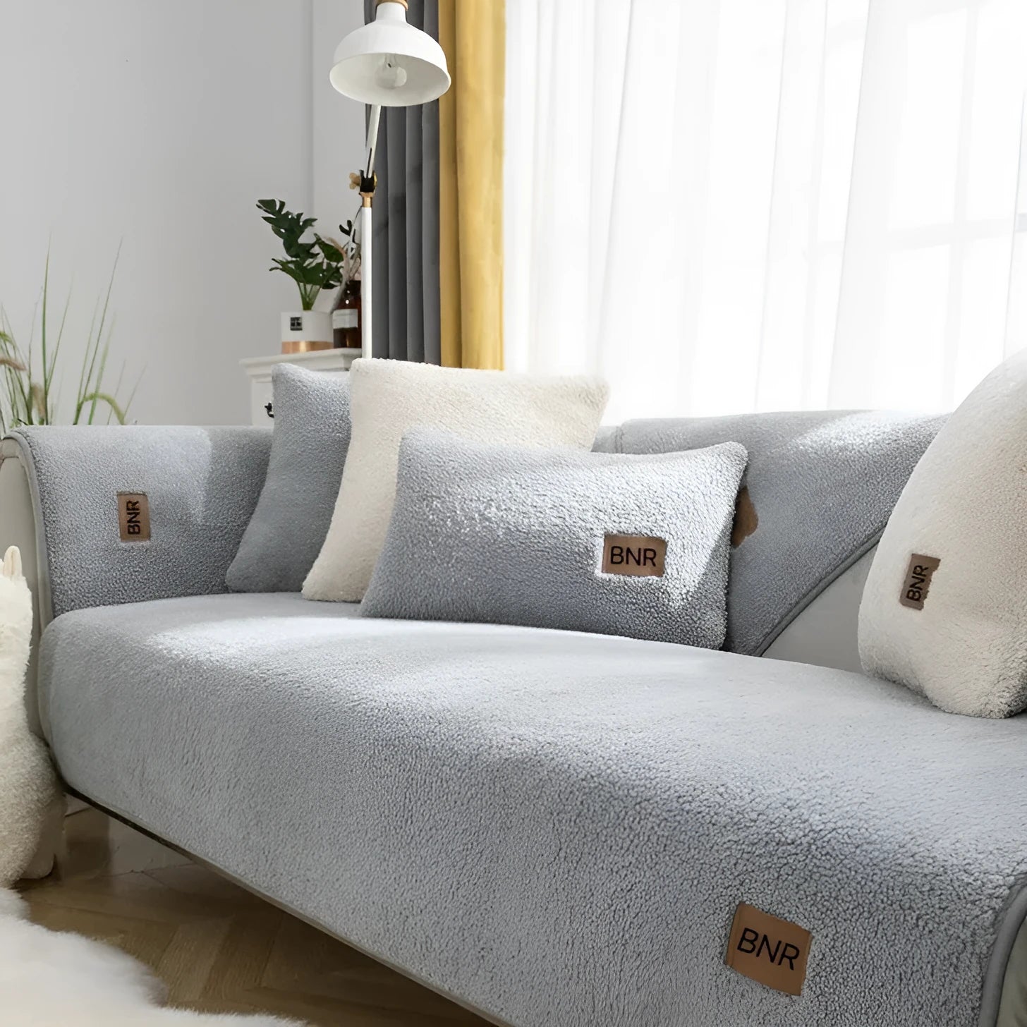 Solid colour lambswool sofa cover draped over a sofa, showing simple style and cloth liner.