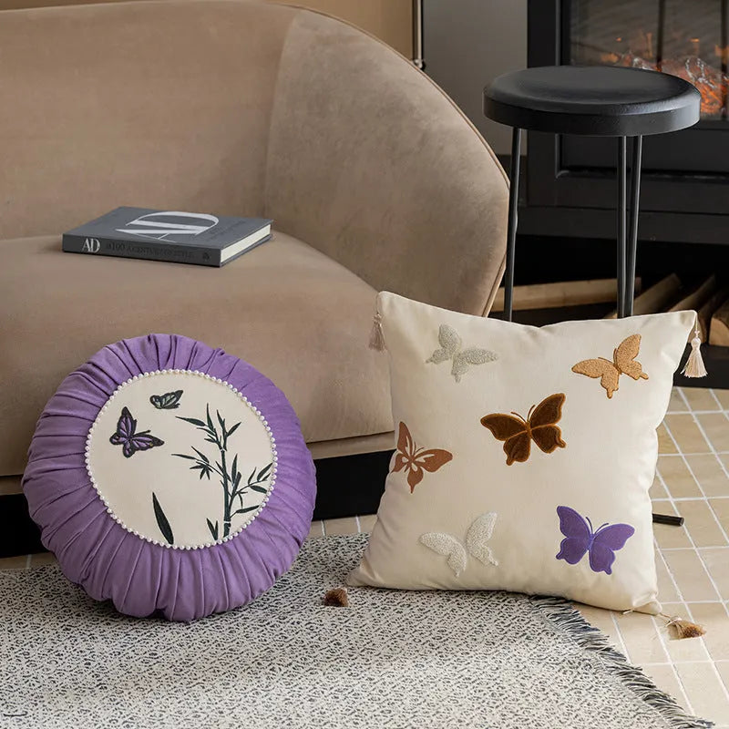Square beige, black, and purple cushion with embroidered Chinese butterfly pattern.