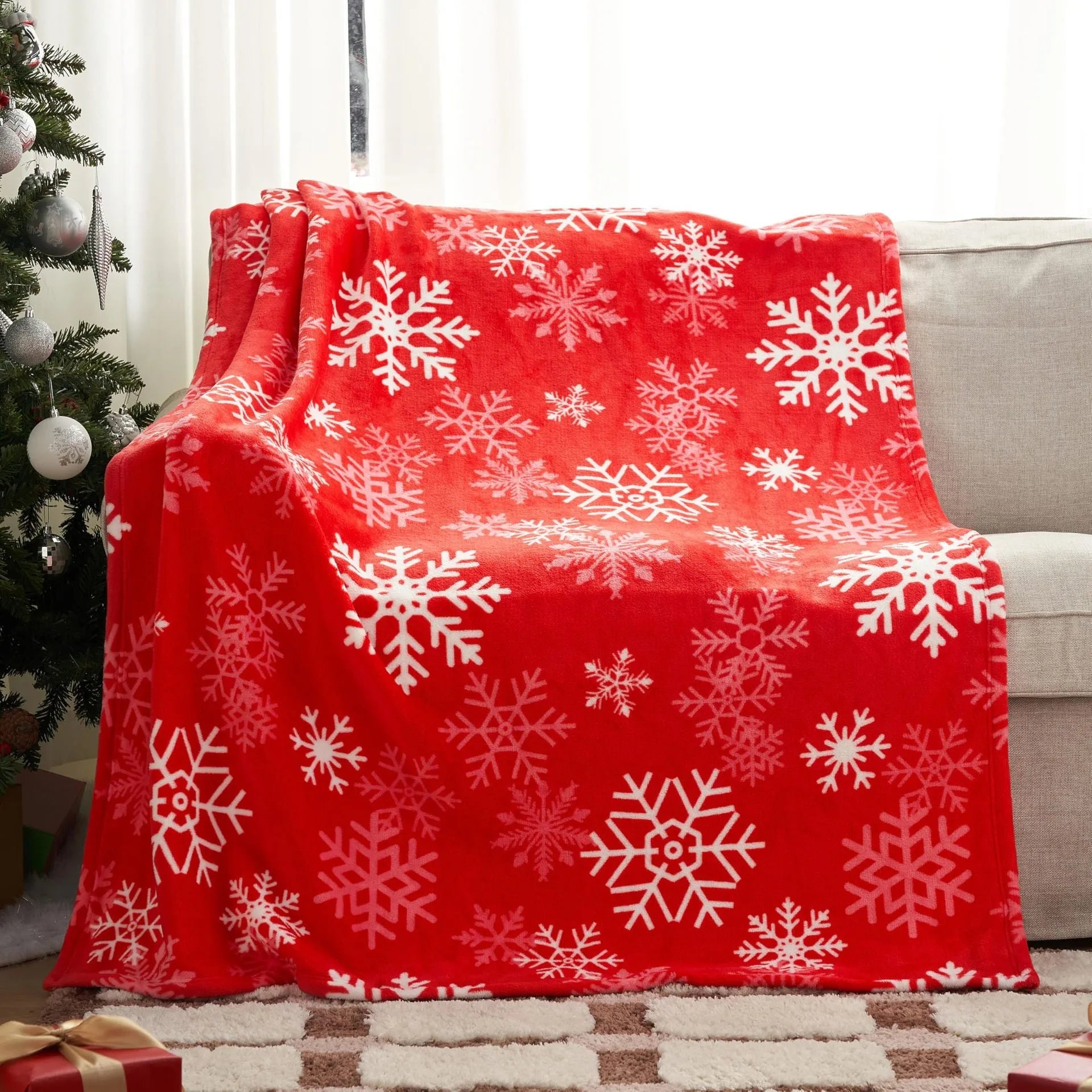 Soft plush flannel Christmas blanket in a choice of colours and sizes on a sofa.