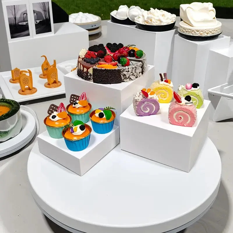 White plastic suit cube dessert display stand 6-piece set arranged in tiered configuration on tabletop