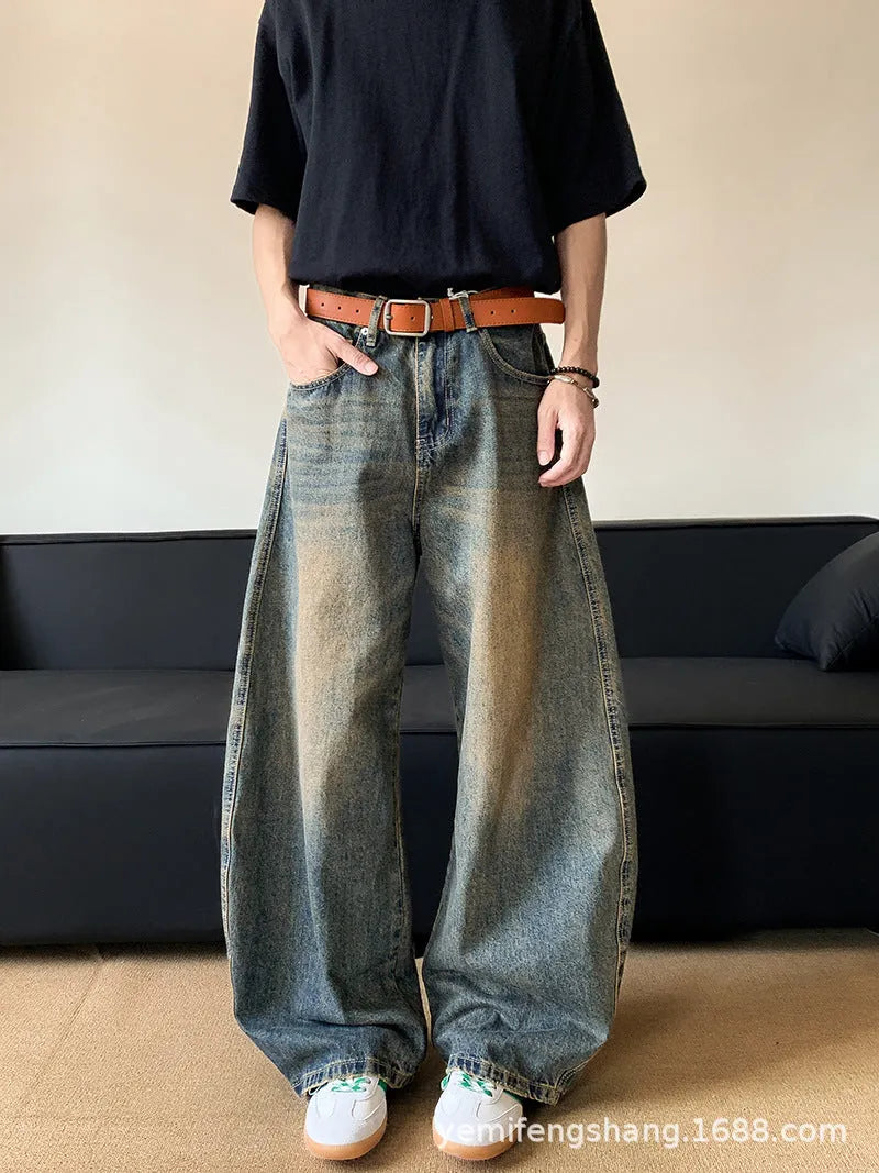 Men's retro blue distressed denim jeans with slim fit wide leg design showing machete wash detailing