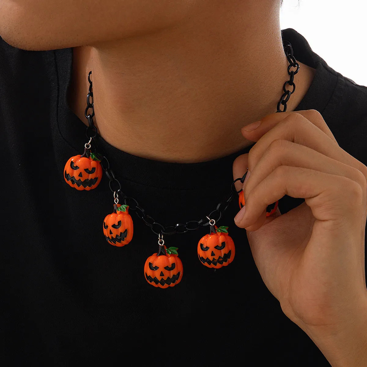 Halloween necklace with a colourful acrylic ghost and pumpkin cartoon pendant on a chain.
