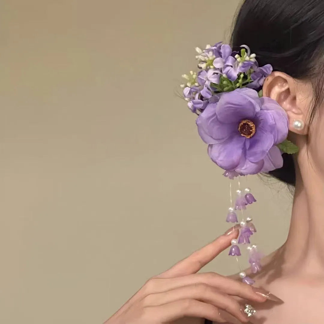 Yellow and purple women's hair clip with pearl details and long floral tassels on a side clip.