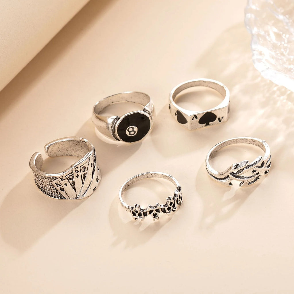 Black alloy ring with a detailed retro spade card design on a finger.