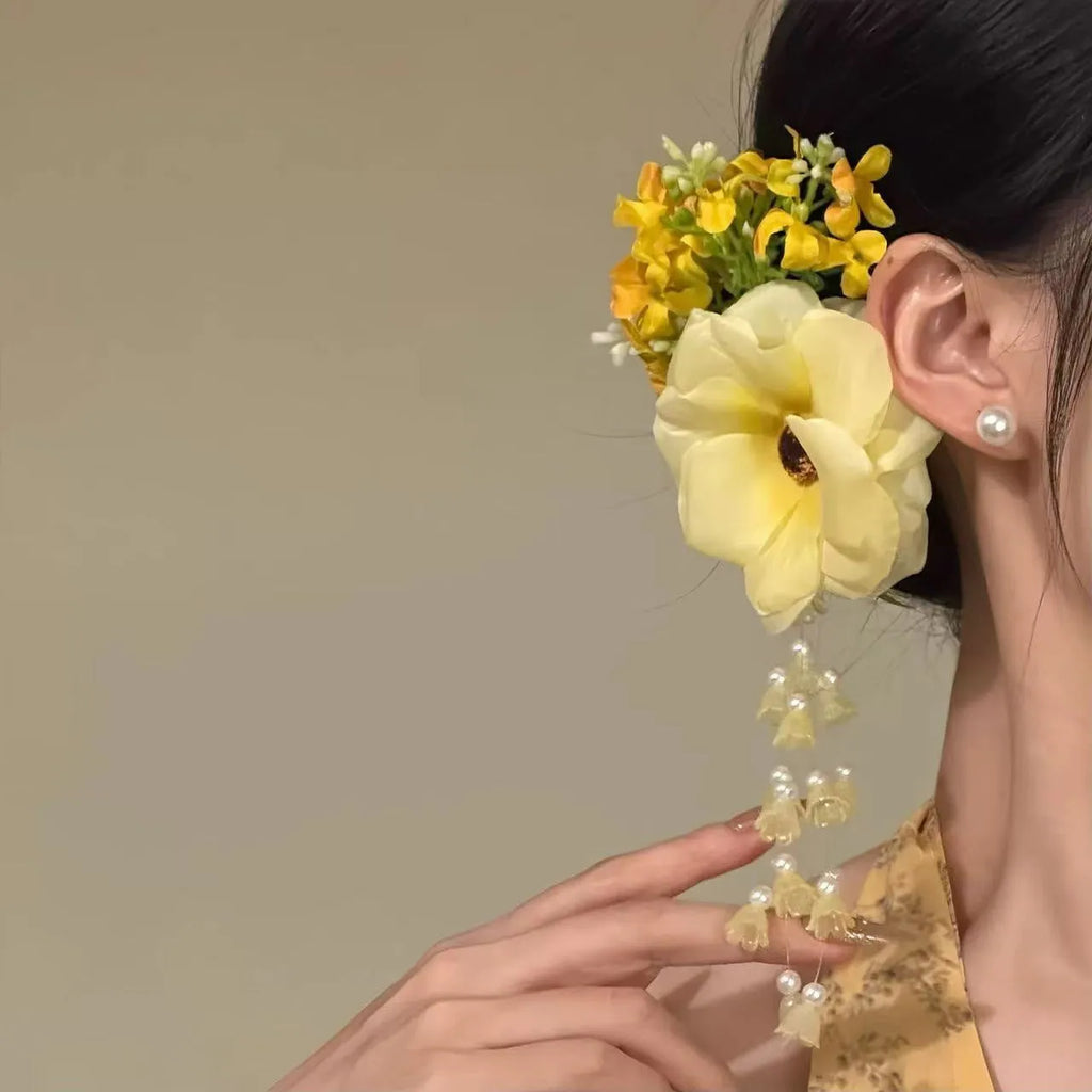 Yellow and purple women's hair clip with pearl details and long floral tassels on a side clip.