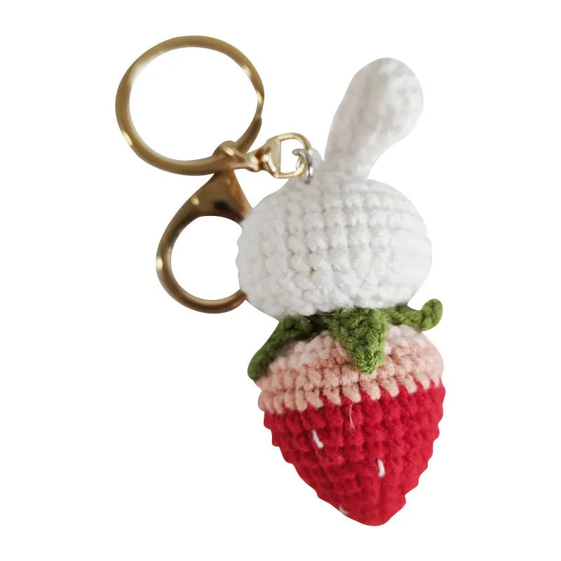 White hand-woven wire pendant of a cartoon rabbit with strawberry details, shown with an attachment key.