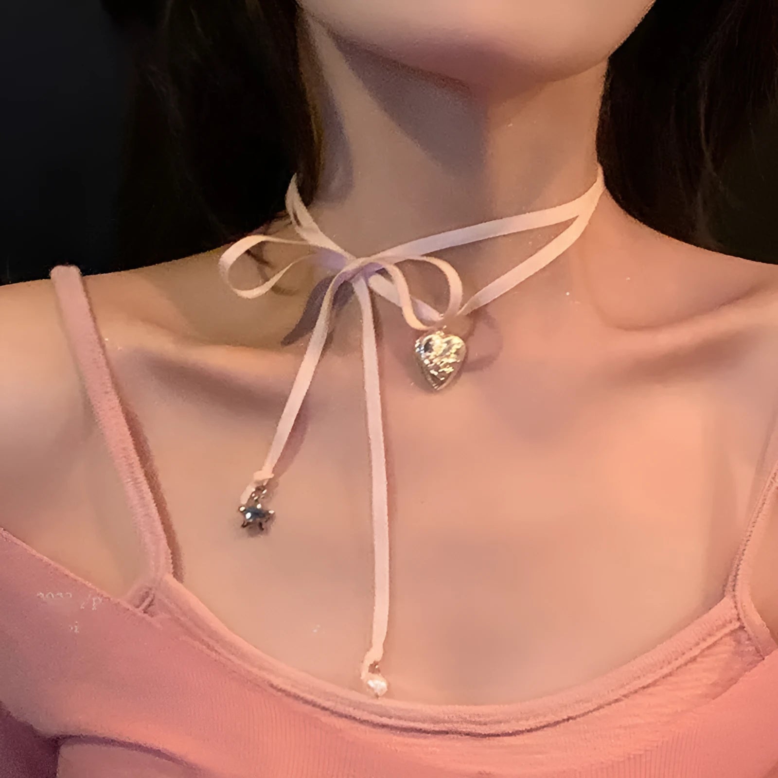 Women's silver-tone alloy necklace with a ribbon-shaped love pendant on a thin chain.