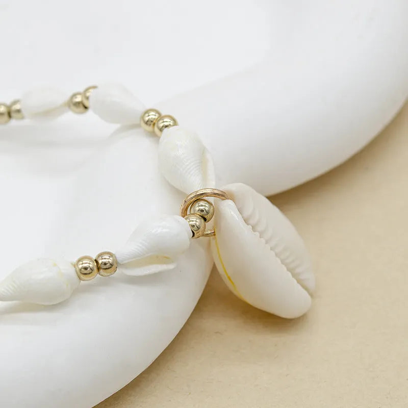 White conch shell necklace with a mother pearl pendant on a regular chain.