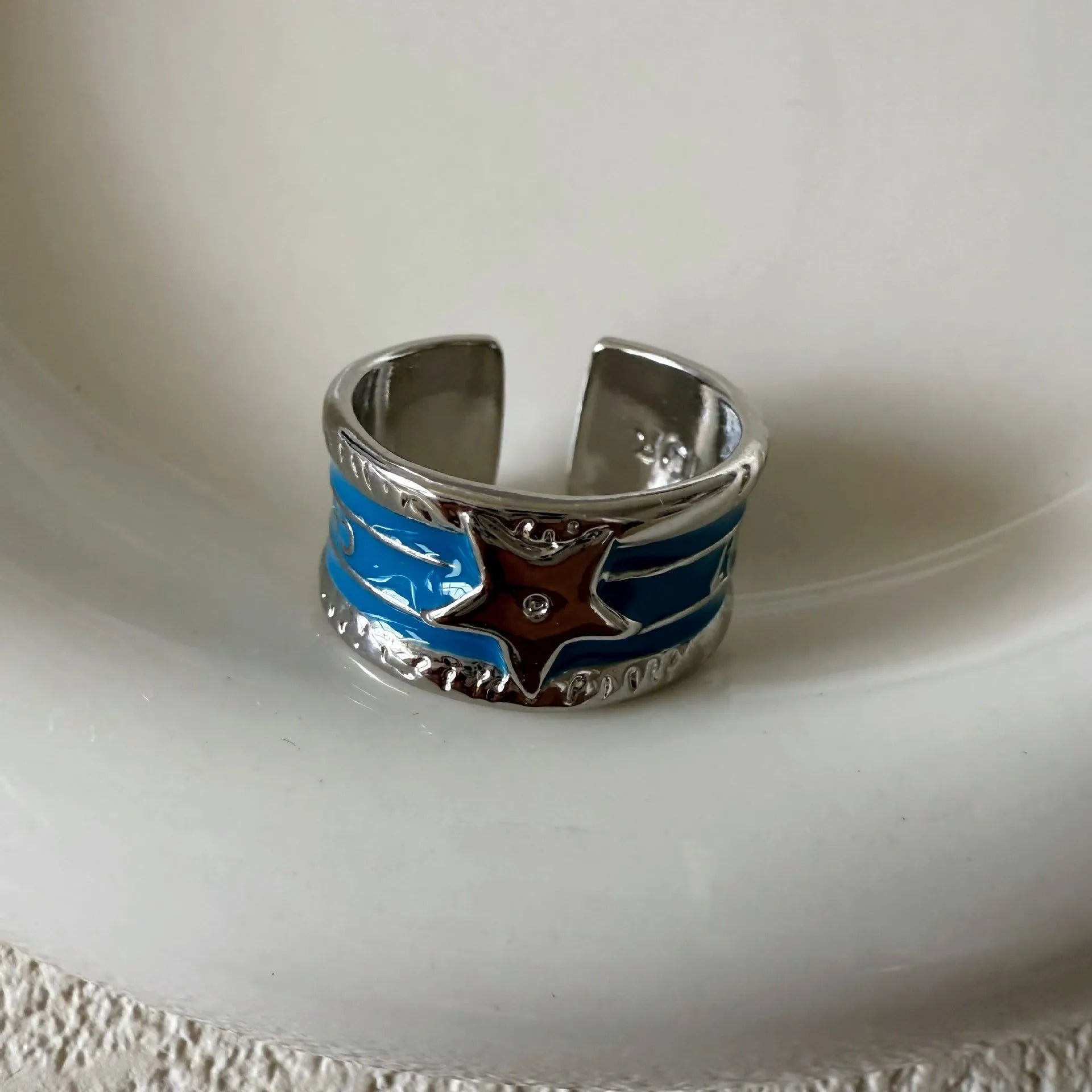Adjustable geometric oil drop ring in distressed retro finish on copper, showing colour options.
