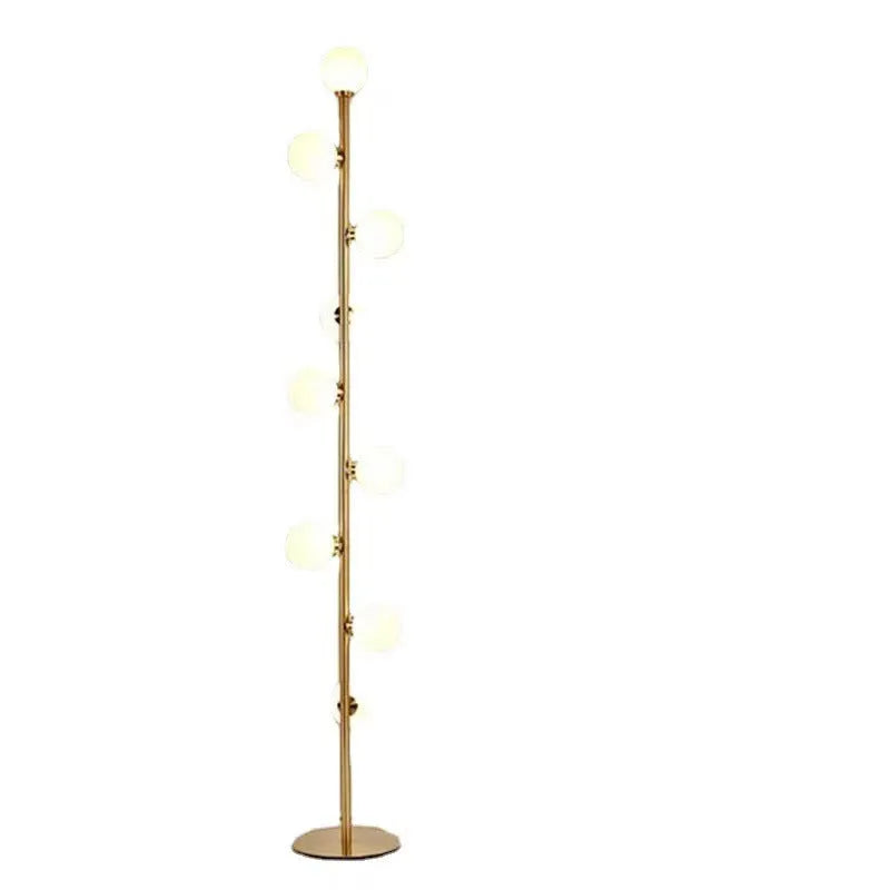 A tall modern minimalist floor lamp with a glass shade, wrought iron frame, and a grey marble base.