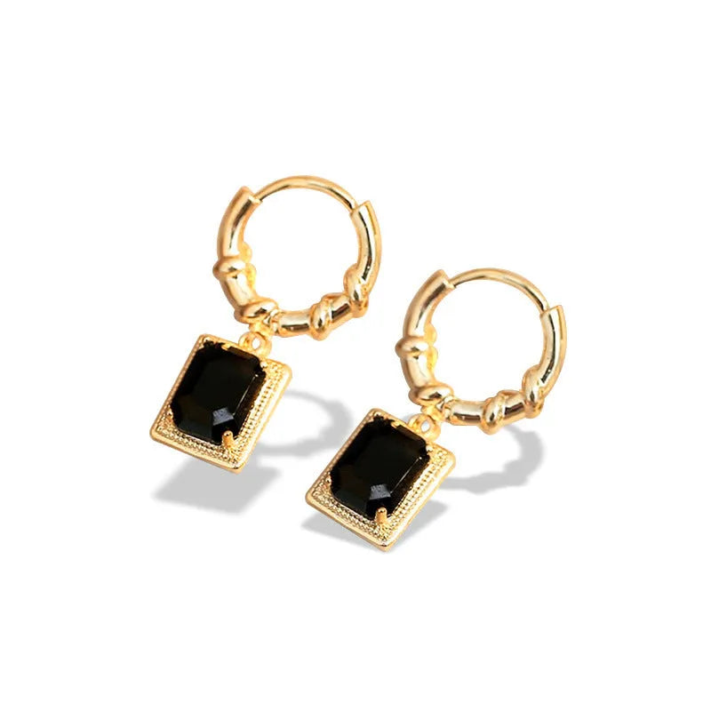 A pair of geometric copper earrings with black zircon stones in a quadrilateral design.