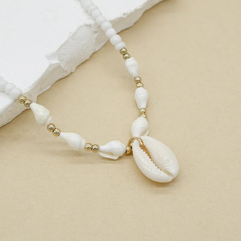 White conch shell necklace with a mother pearl pendant on a regular chain.