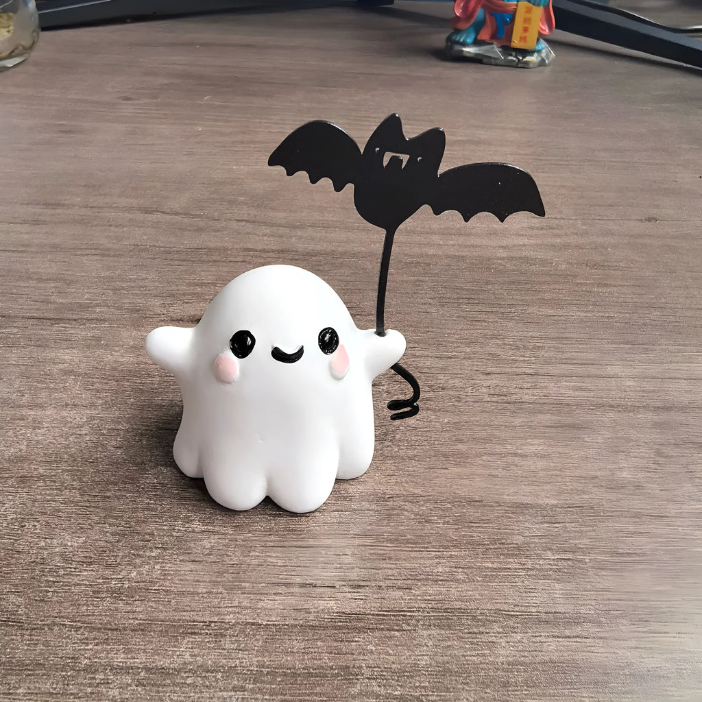 Small white resin statue of a ghost walking a spectral dog, a Halloween decoration.