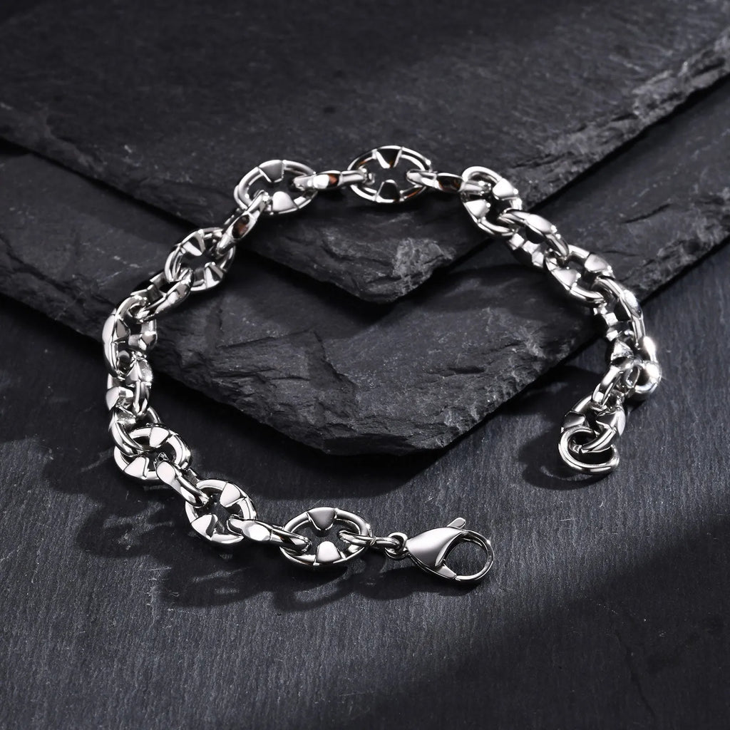 Close-up of a men's thick stainless steel geometric chain link bracelet on a wrist.