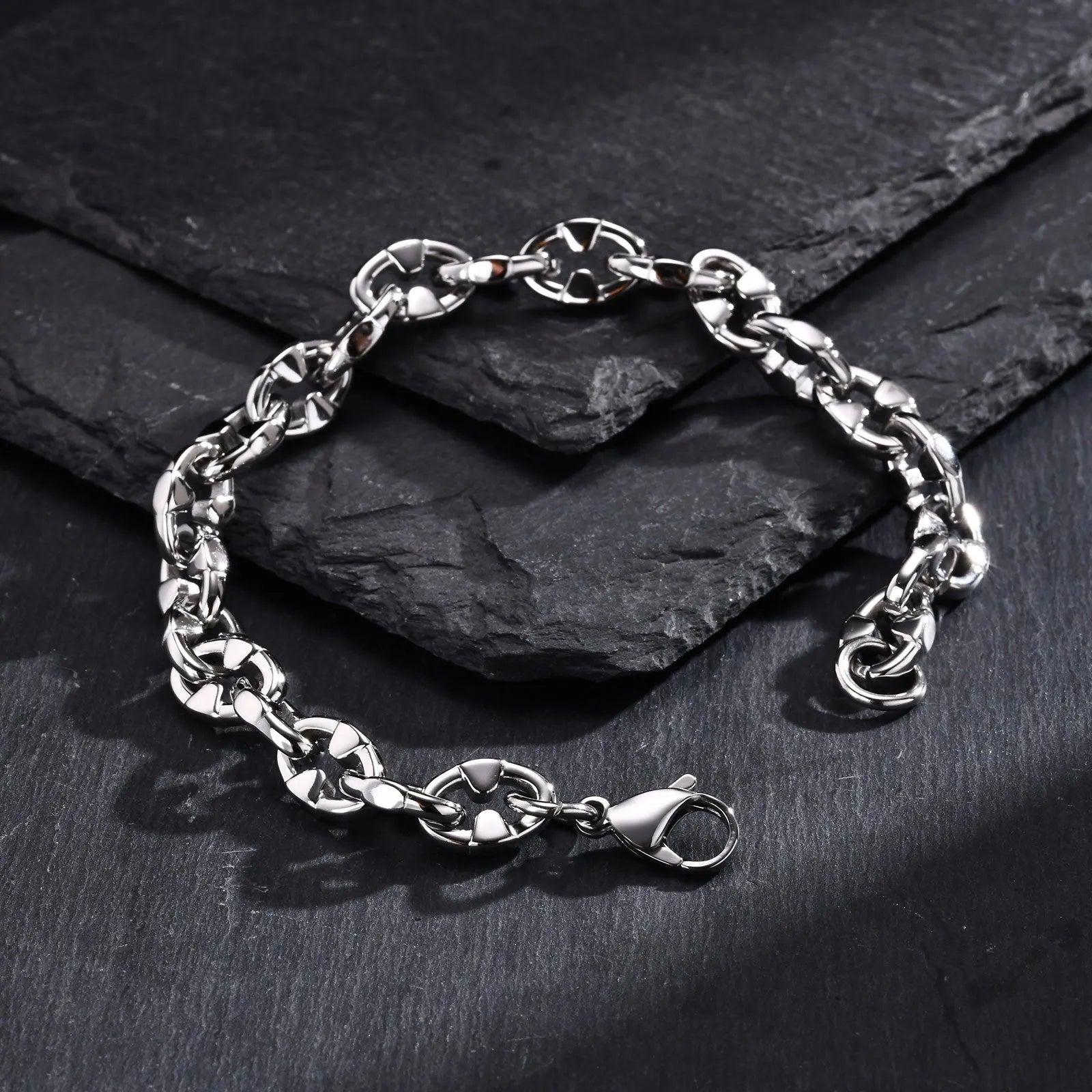Close-up of a men's thick stainless steel geometric chain link bracelet on a wrist.