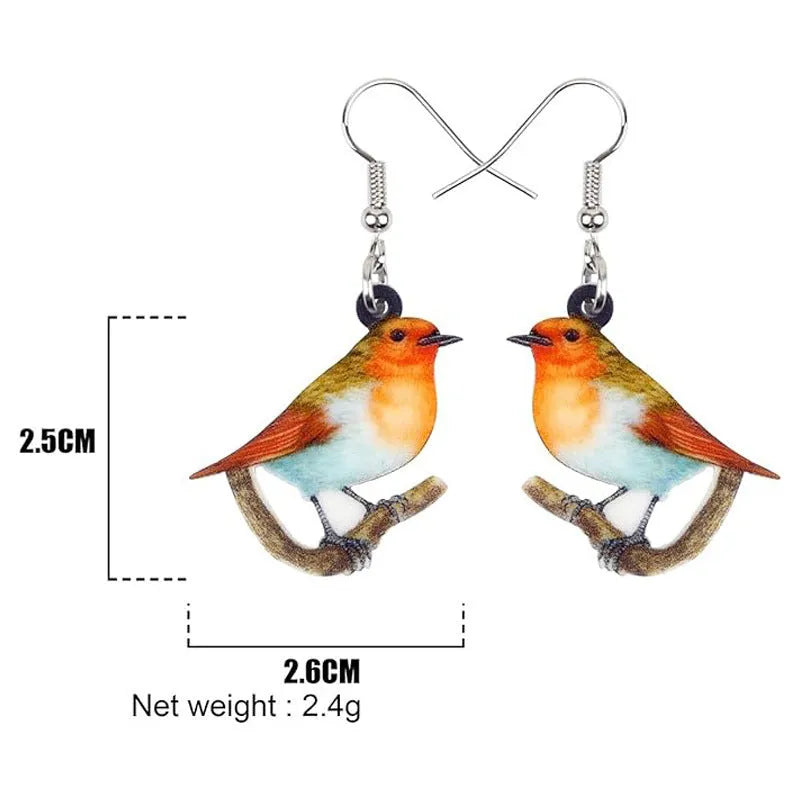 A pair of blue titmouse pendant earrings made from acrylic with printed snake and geometric designs.