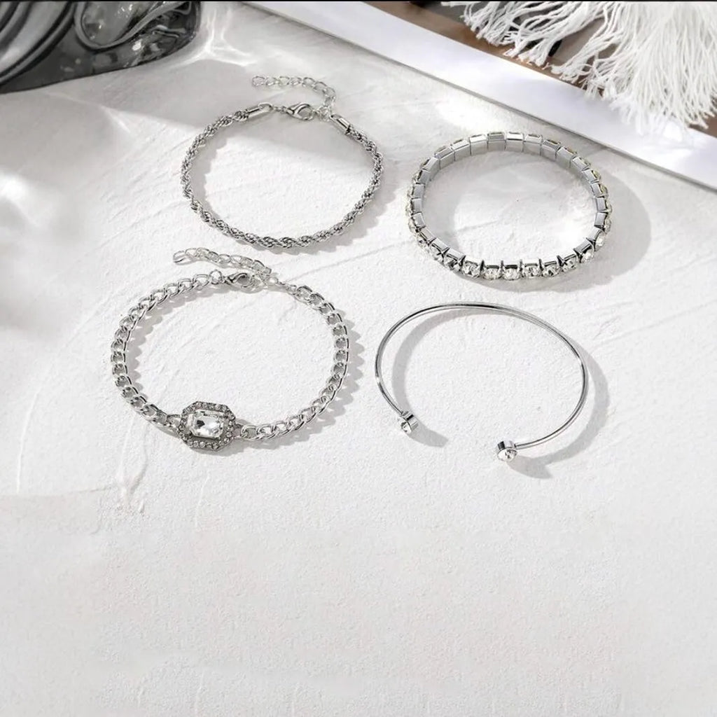 Four geometric bracelets with square diamond motifs on metal chains in gold colour