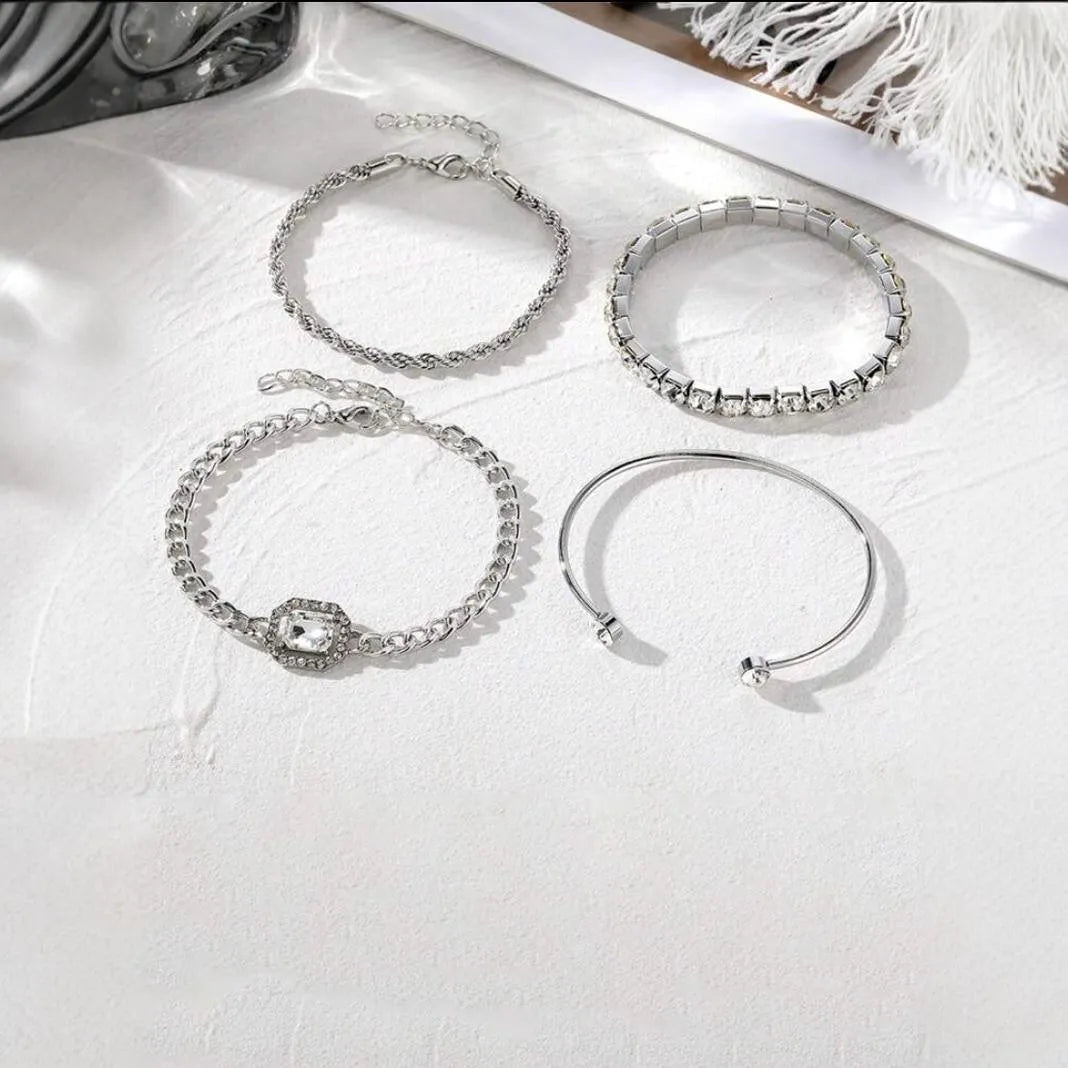 Four geometric bracelets with square diamond motifs on metal chains in gold colour