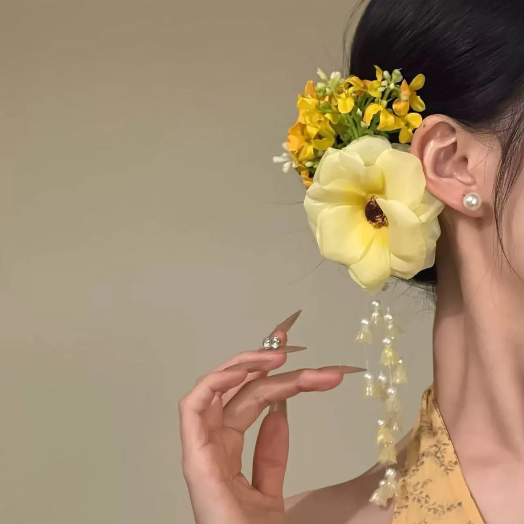 Yellow and purple women's hair clip with pearl details and long floral tassels on a side clip.