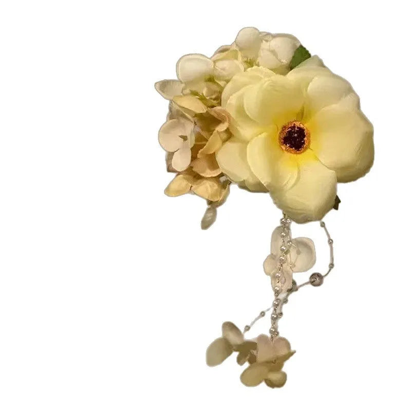 Yellow and purple women's hair clip with pearl details and long floral tassels on a side clip.