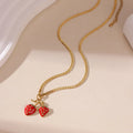 Close-up of a women's strawberry fruit pendant necklace with a detailed alloy charm on a stainless steel chain.