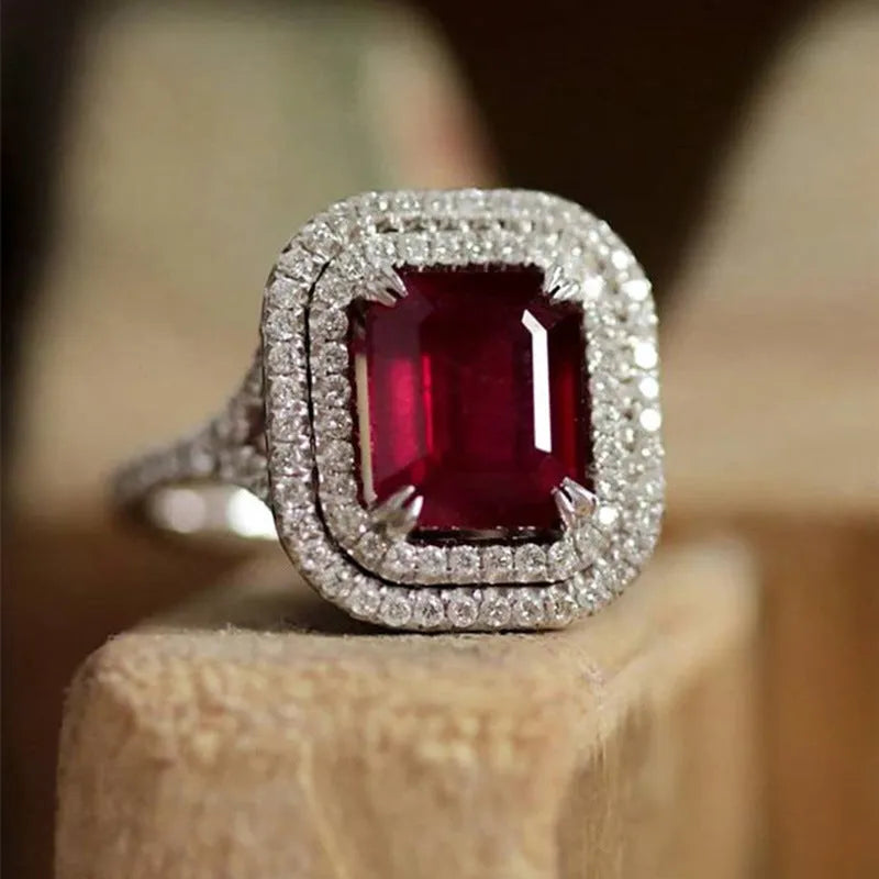 Copper square ring with a large red princess-cut rhinestone on a model's finger.