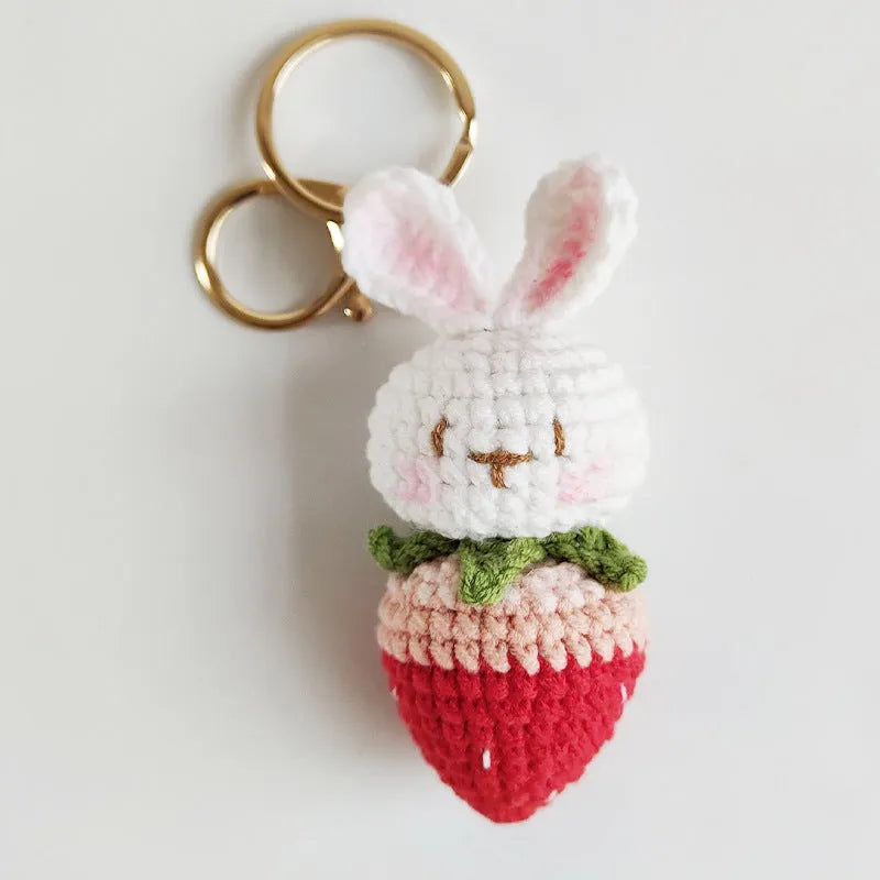 White hand-woven wire pendant of a cartoon rabbit with strawberry details, shown with an attachment key.