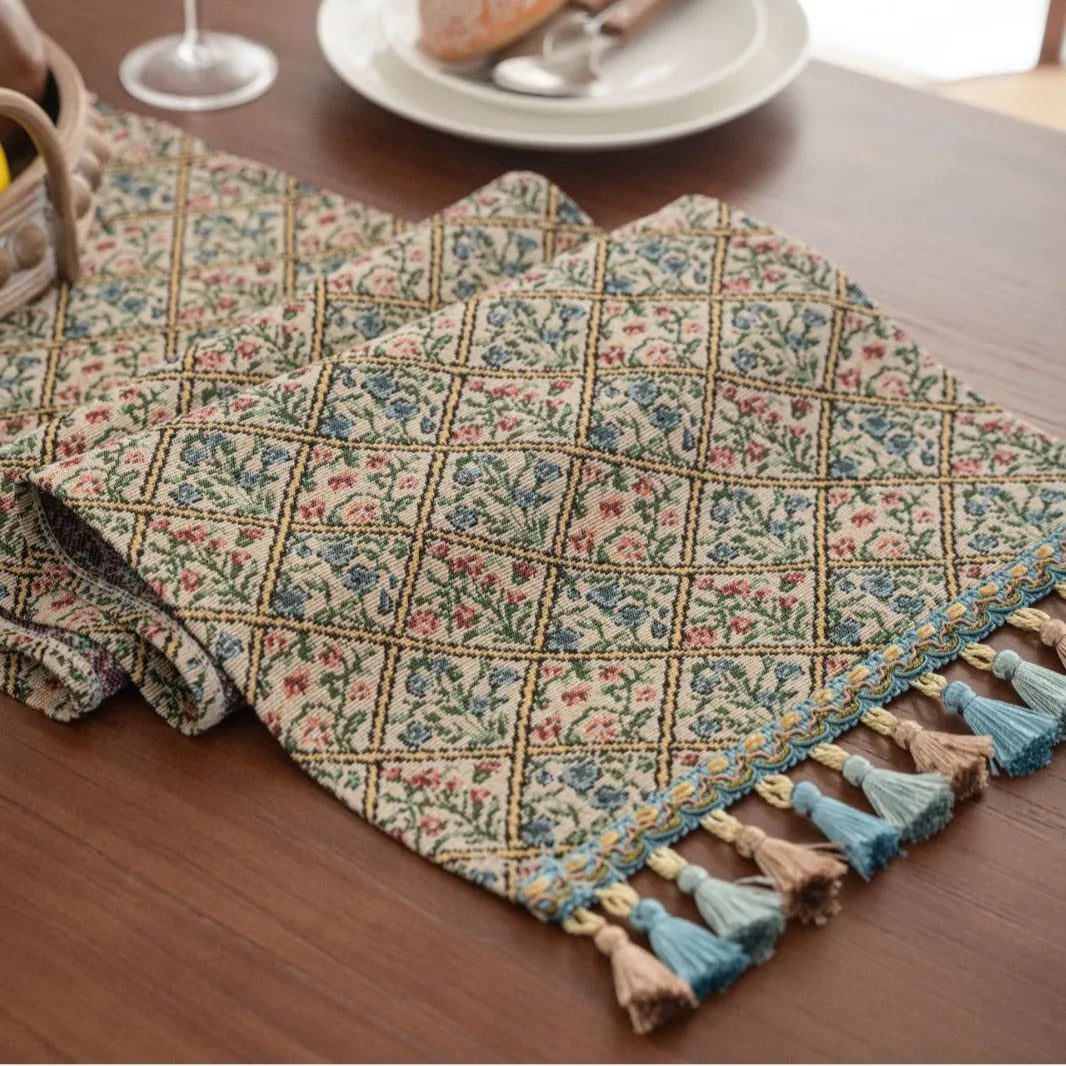 Nordic jacquard bouquet pattern table runner with tassel trim in dark blue on a dining table.