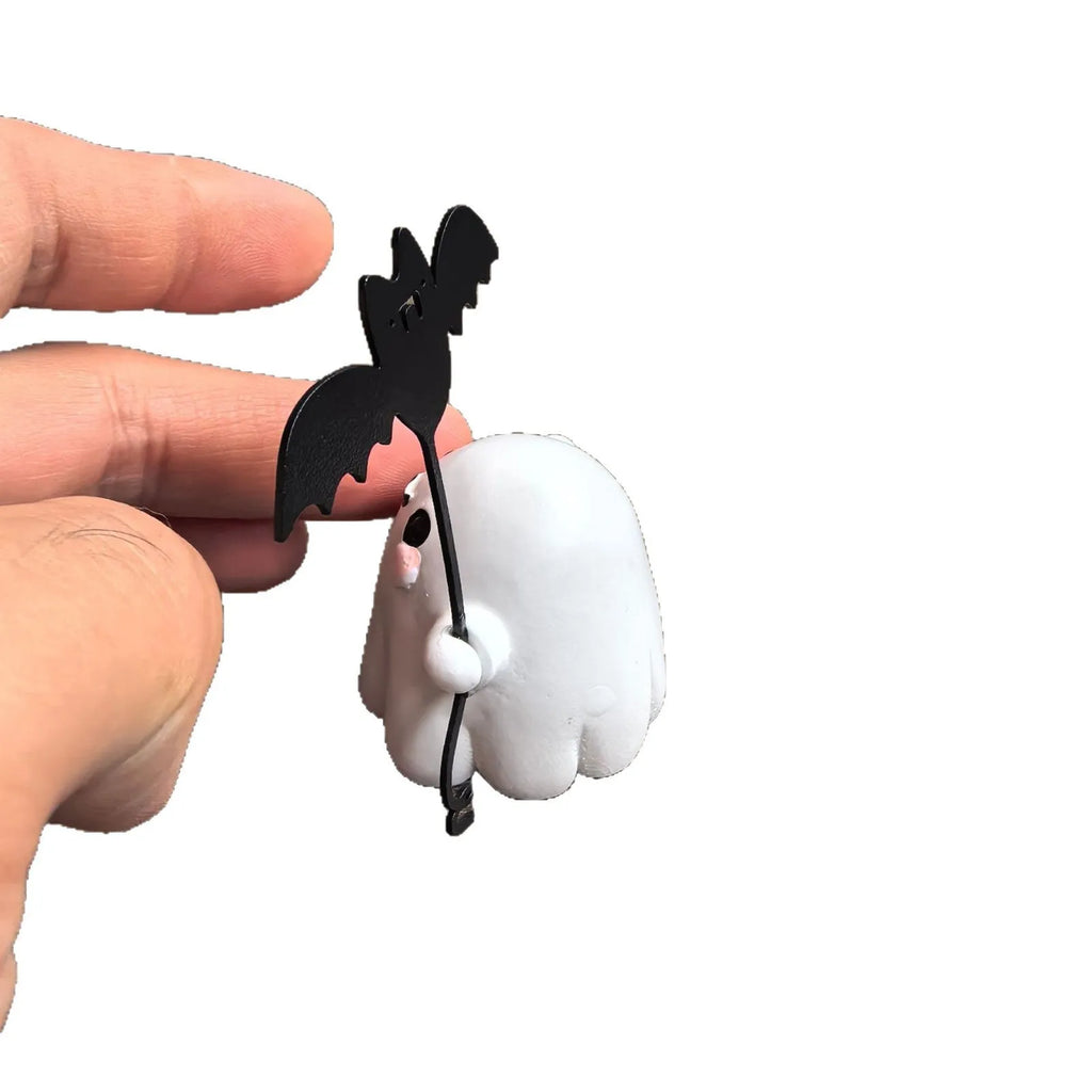 Small white resin statue of a ghost walking a spectral dog, a Halloween decoration.
