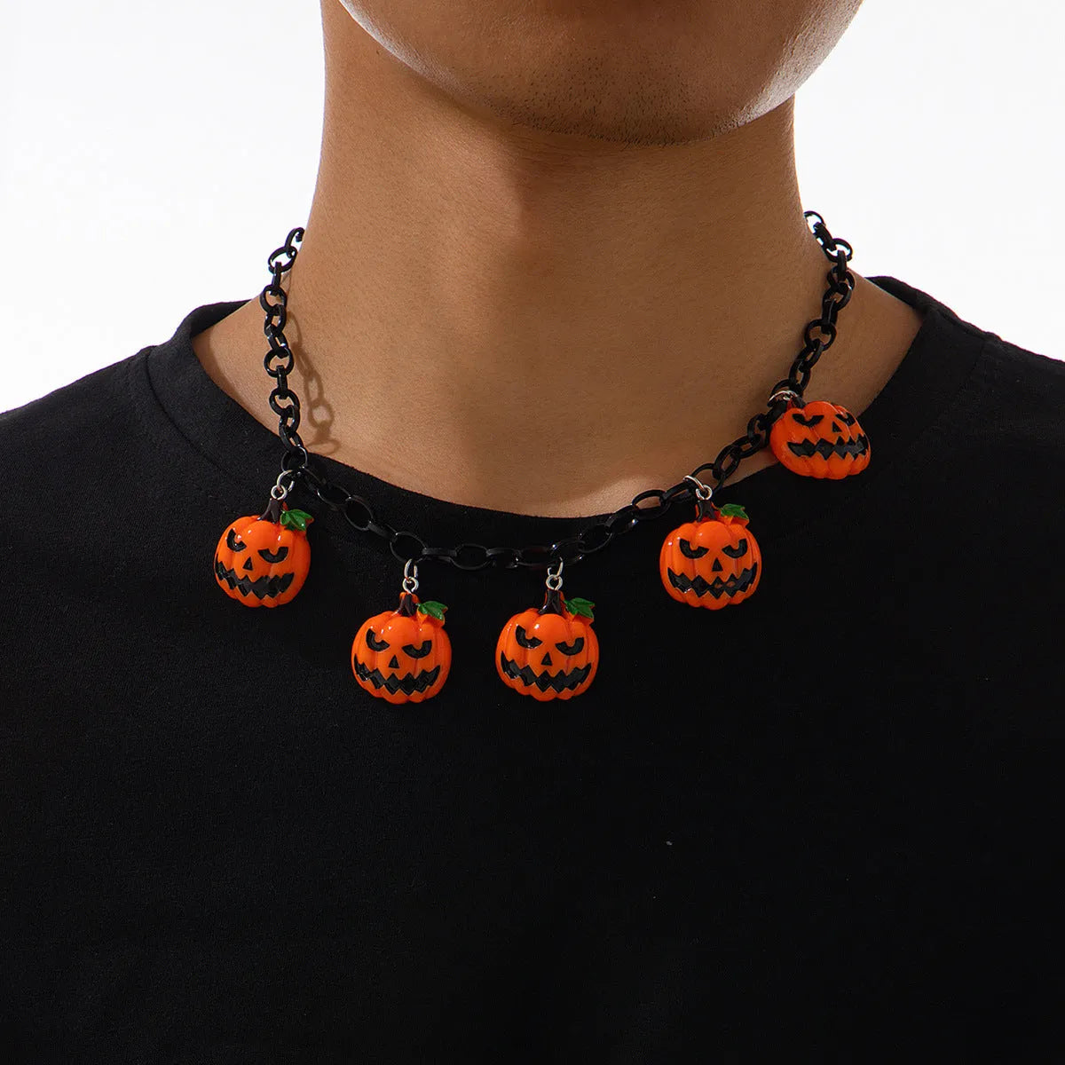 Halloween necklace with a colourful acrylic ghost and pumpkin cartoon pendant on a chain.