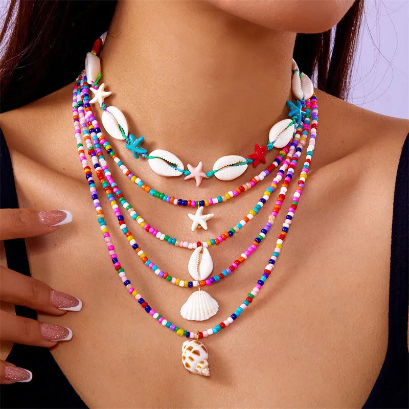 Five women's necklaces with starfish shell conch bead designs in blue and multicolour with alloy pendants