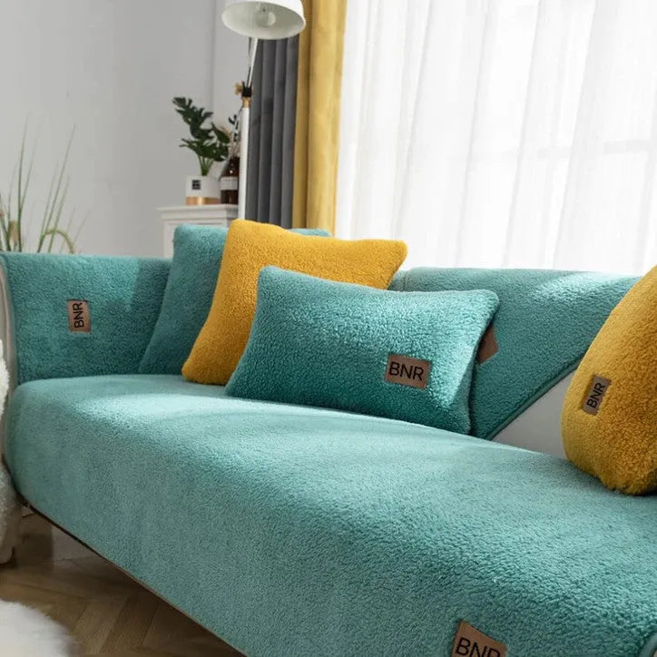 Solid colour lambswool sofa cover draped over a sofa, showing simple style and cloth liner.