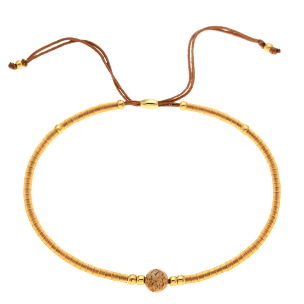 Women's handmade geometric beaded bracelet in bohemian style with glass and coloured glaze materials