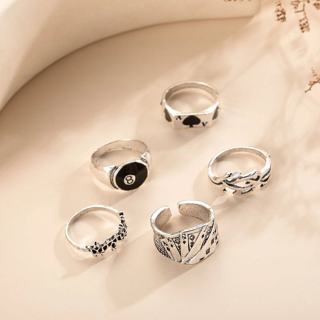 Black alloy ring with a detailed retro spade card design on a finger.