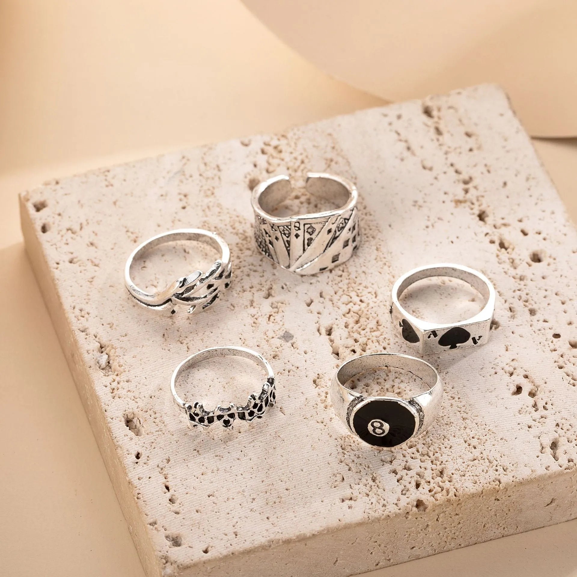 Black alloy ring with a detailed retro spade card design on a finger.