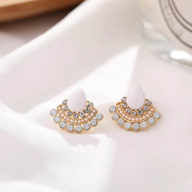A pair of silver-toned retro fan-shaped drop earrings with a needle opal centre and sparkling rhinestone details.