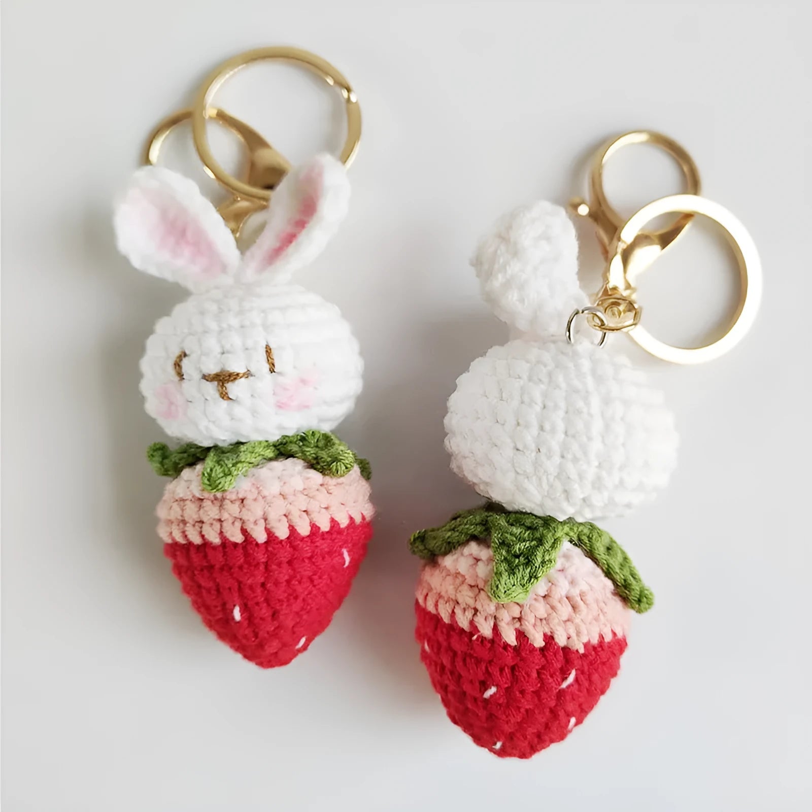 White hand-woven wire pendant of a cartoon rabbit with strawberry details, shown with an attachment key.