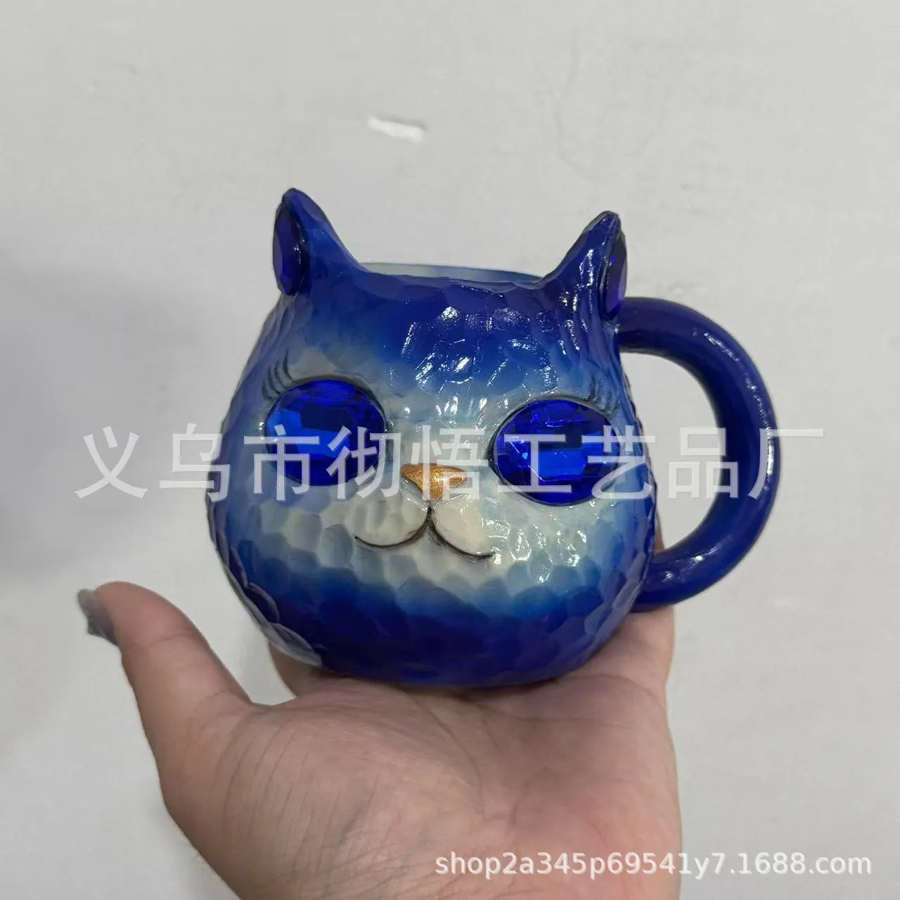 American-style resin ornament of a cat holding a crystal Earth globe in blue, green, pink, or purple.
