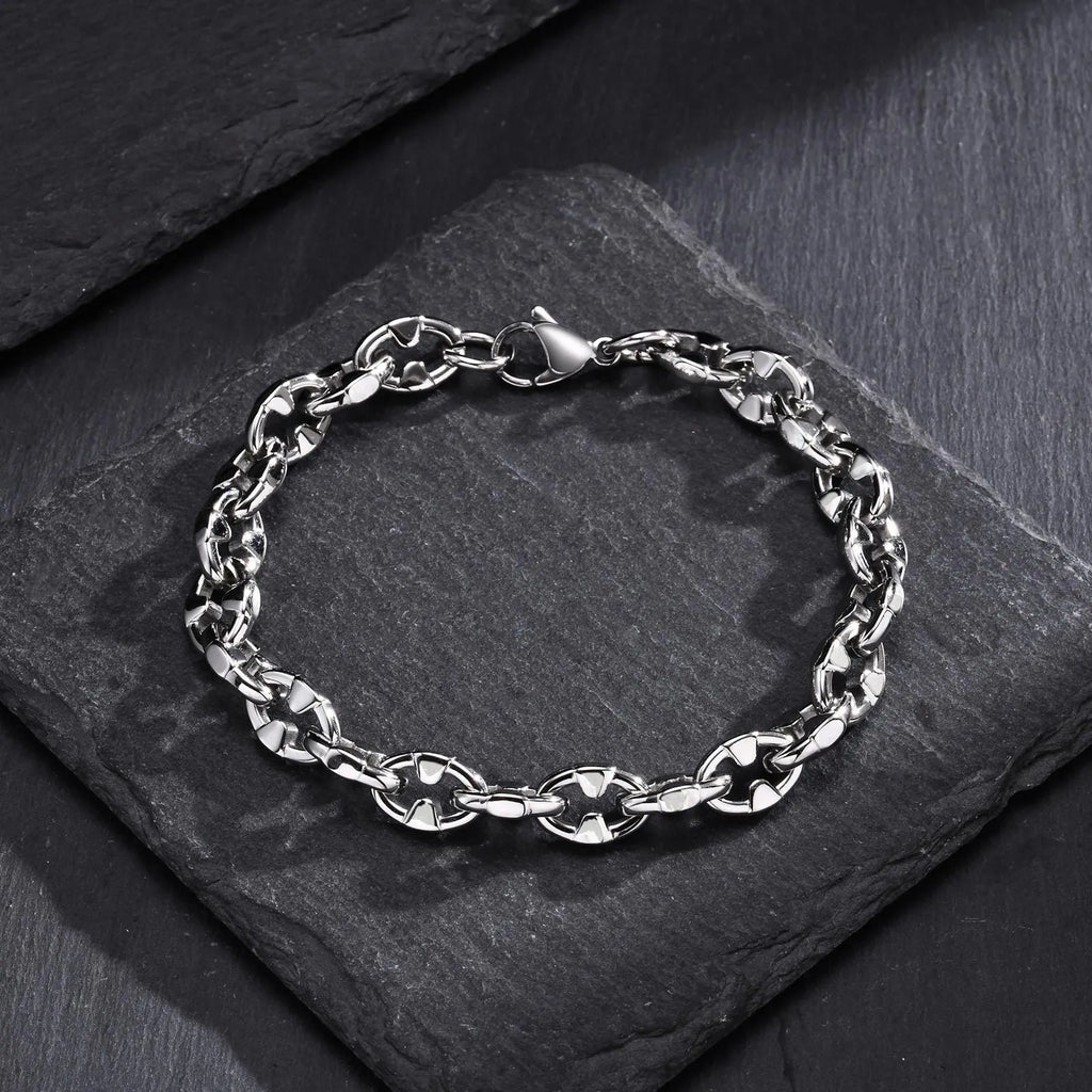 Close-up of a men's thick stainless steel geometric chain link bracelet on a wrist.