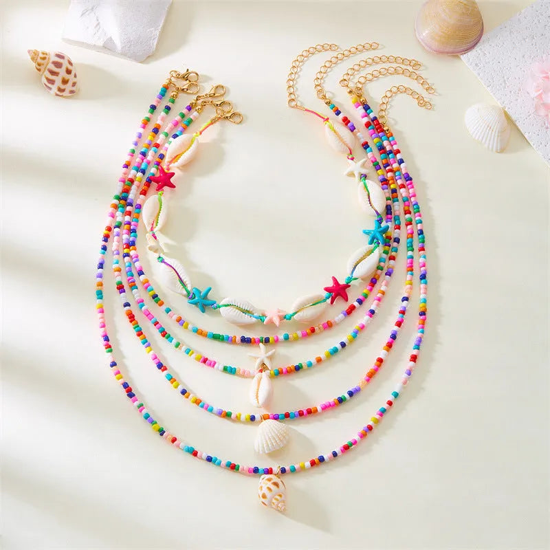 Five women's necklaces with starfish shell conch bead designs in blue and multicolour with alloy pendants