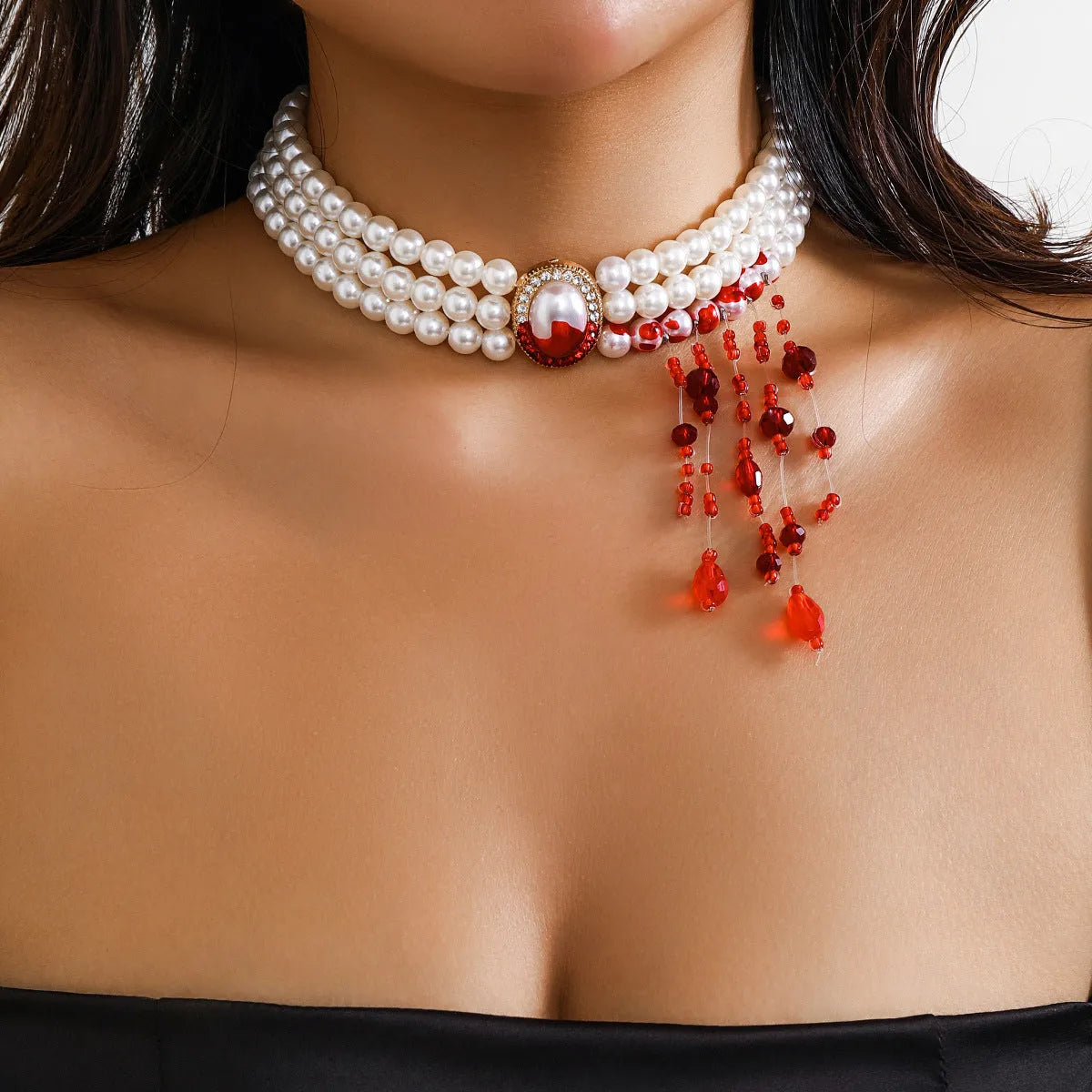 Halloween gothic jewellery set with pearl collar necklace, gold bracelet, and stud earrings on a dark background.