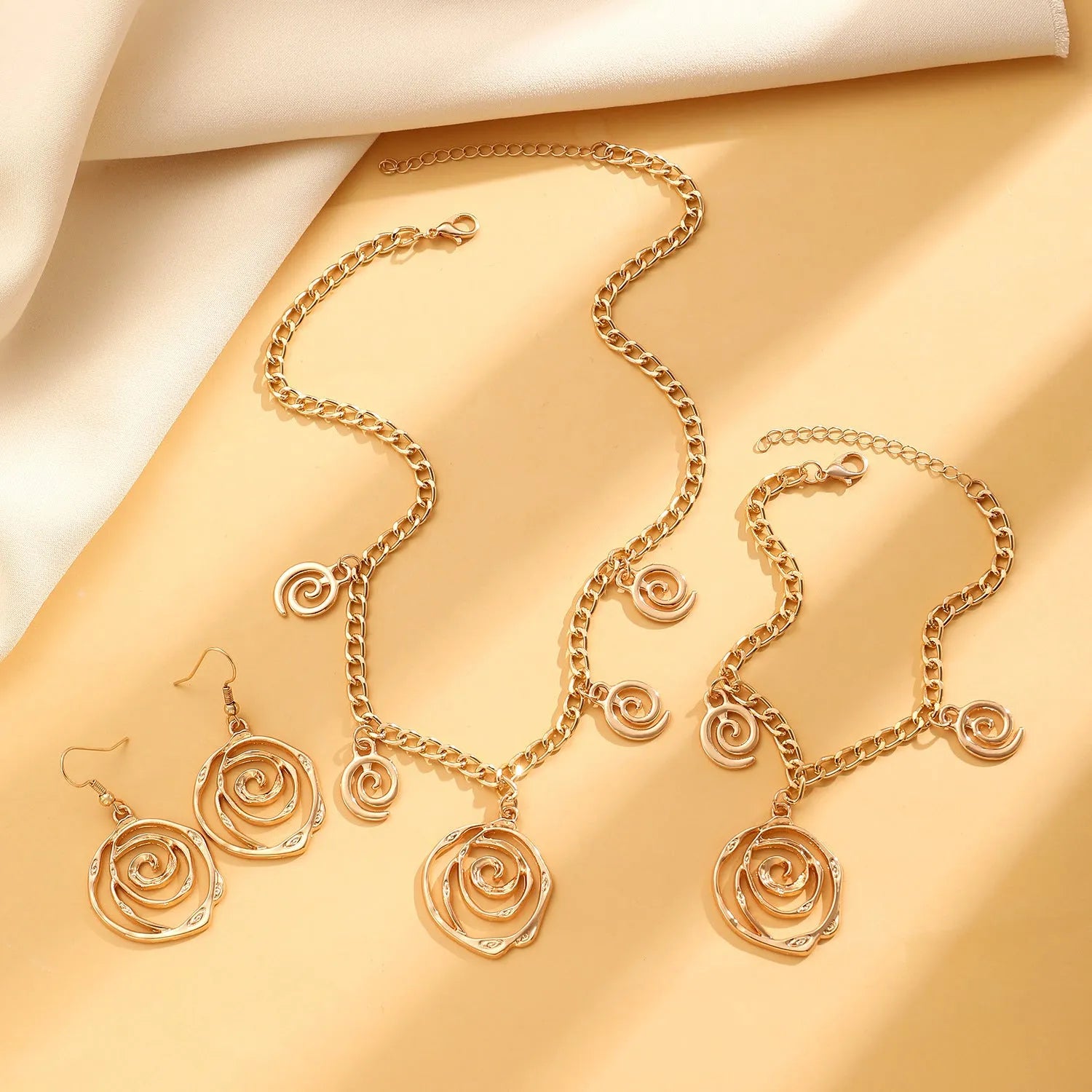 Spiral donut jewellery set showing necklace, bracelet and ear hooks with geometric circle design