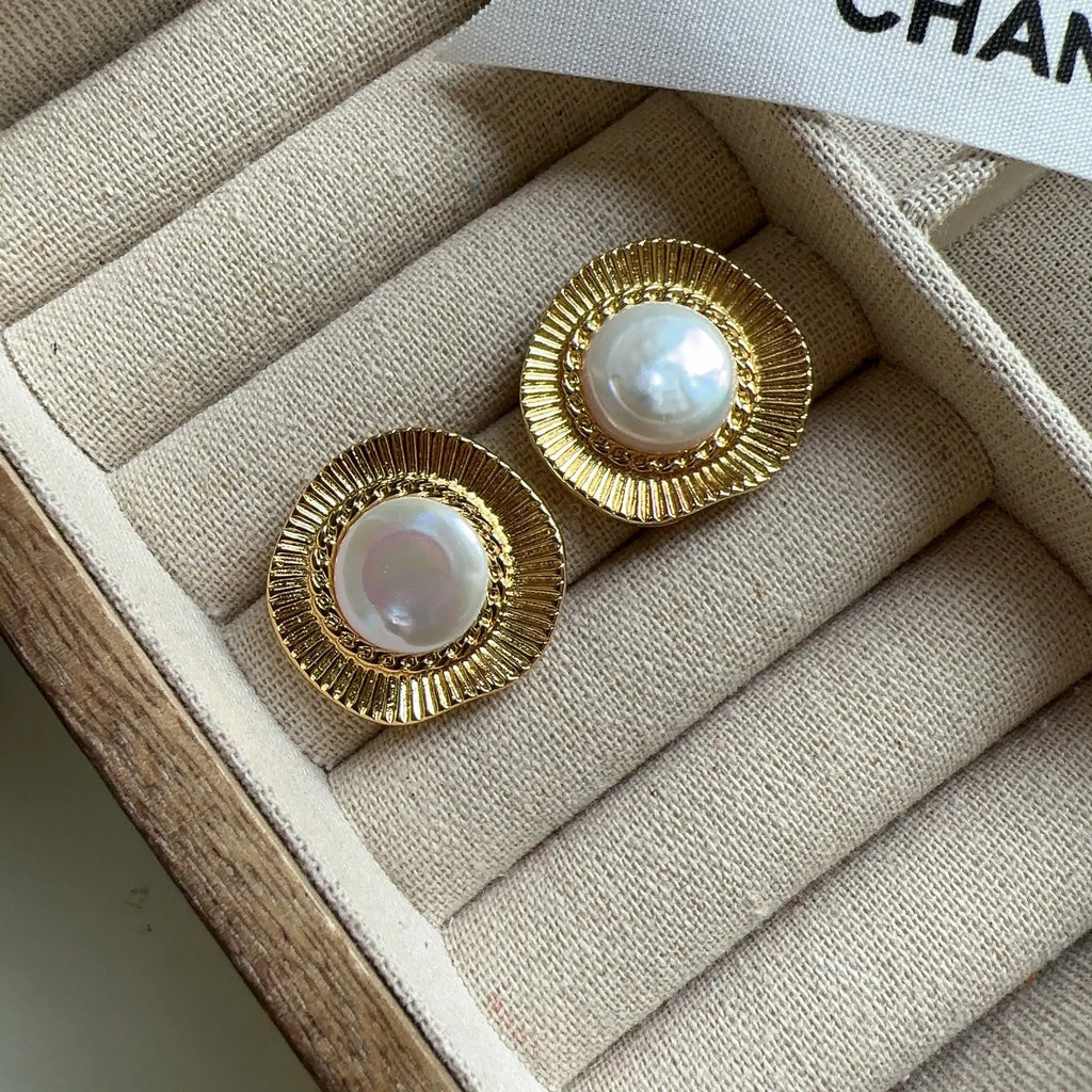 A pair of round gold-coloured retro earrings for women with a simple design.