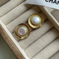 A pair of round gold-coloured retro earrings for women with a simple design.