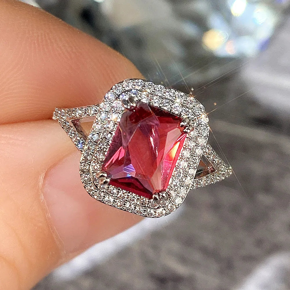 Copper square ring with a large red princess-cut rhinestone on a model's finger.