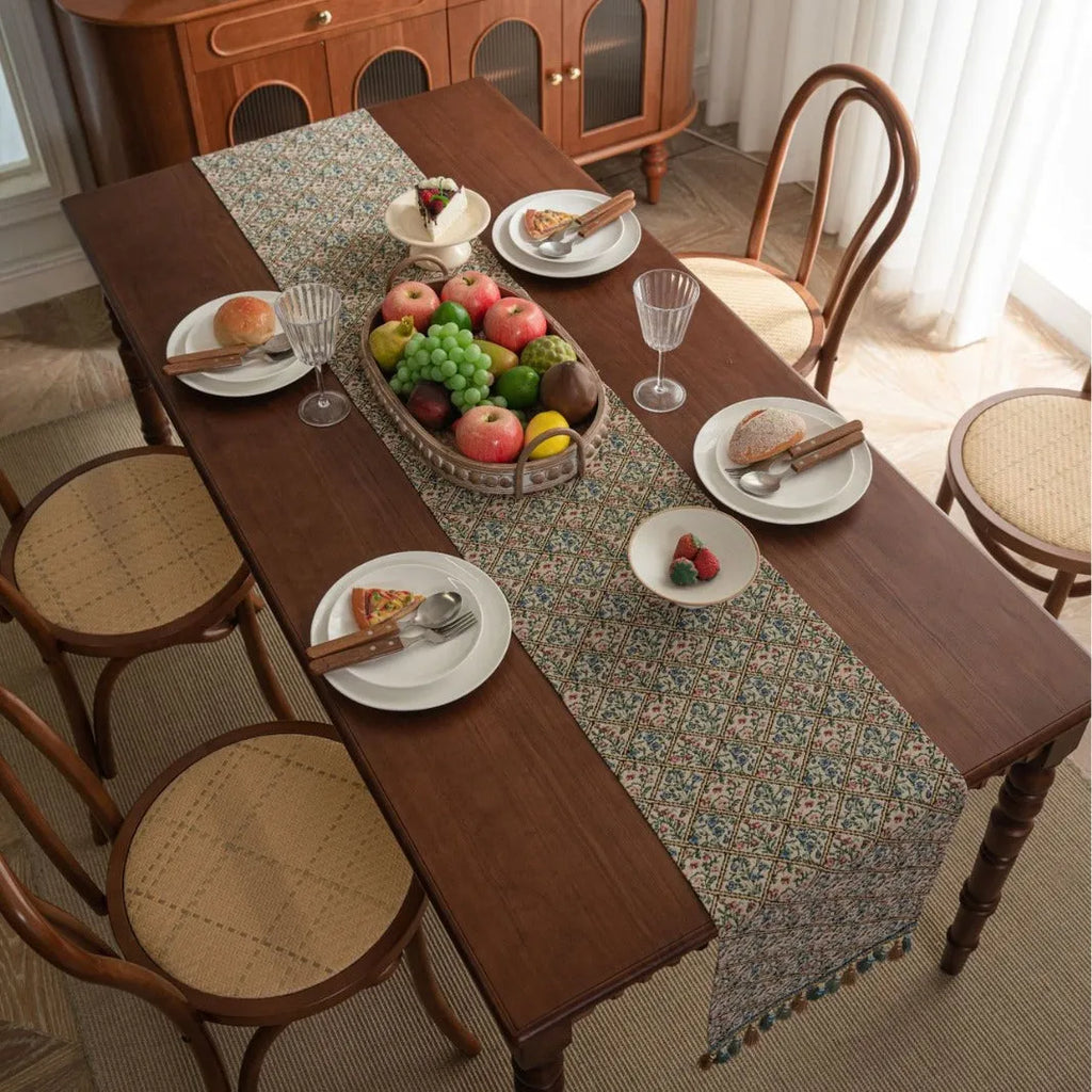 Nordic jacquard bouquet pattern table runner with tassel trim in dark blue on a dining table.