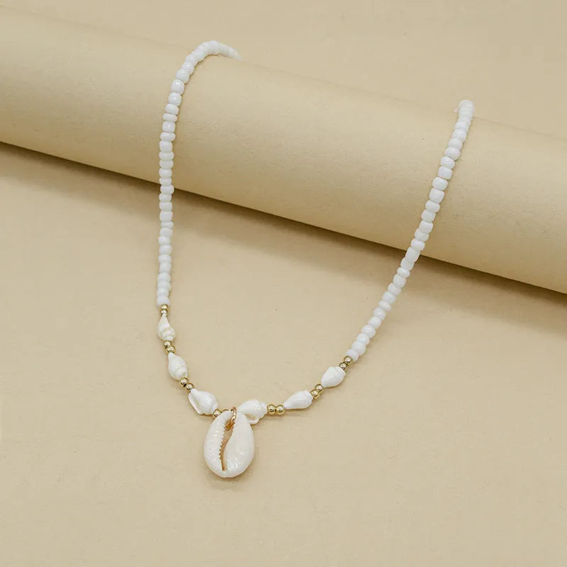 White conch shell necklace with a mother pearl pendant on a regular chain.