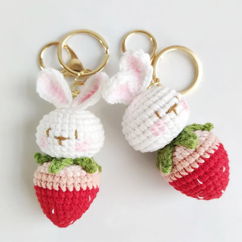 White hand-woven wire pendant of a cartoon rabbit with strawberry details, shown with an attachment key.