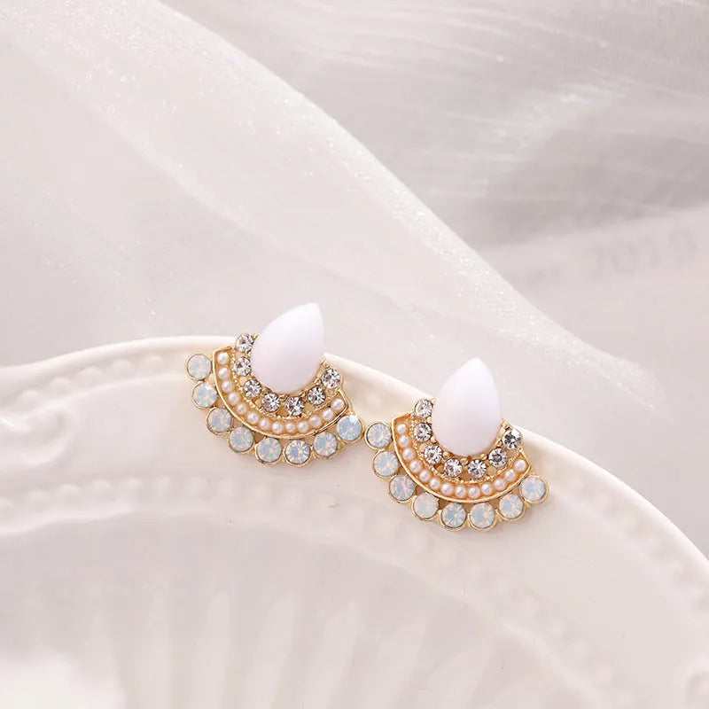 A pair of silver-toned retro fan-shaped drop earrings with a needle opal centre and sparkling rhinestone details.